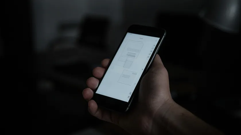 Hand holding an iPhone in a dim room showing a document page with a column of tool icons along the right edge